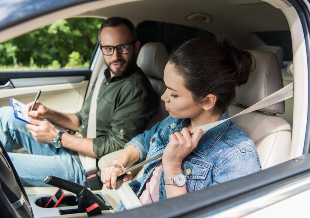 student-fastening-seat-belt-in-car-during-driving-test.jpg